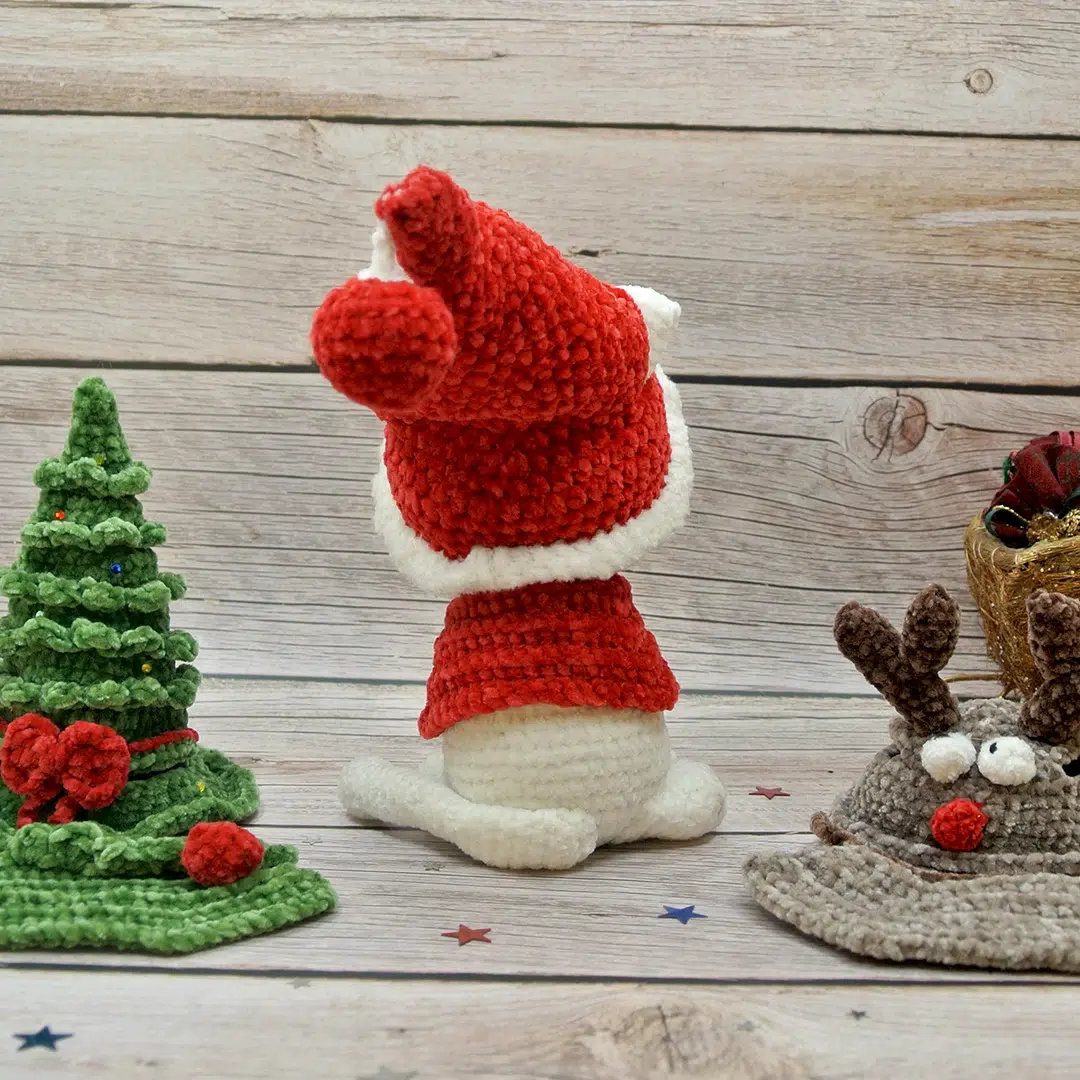 Chat blanc au crochet de Noël et ses habits rouges vu de dos