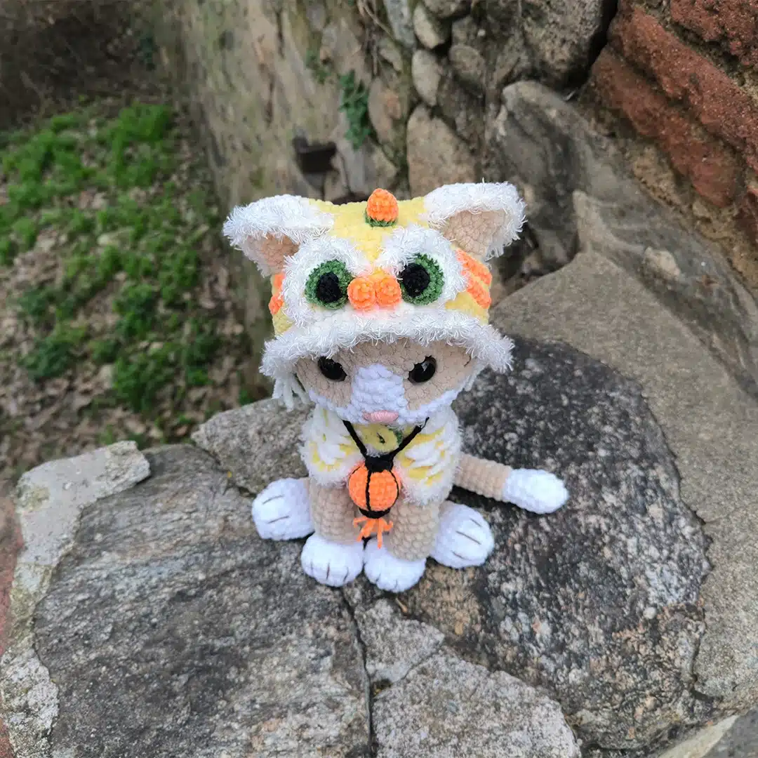 Chat au crochet et son habit jaune de dragon vu de dessus