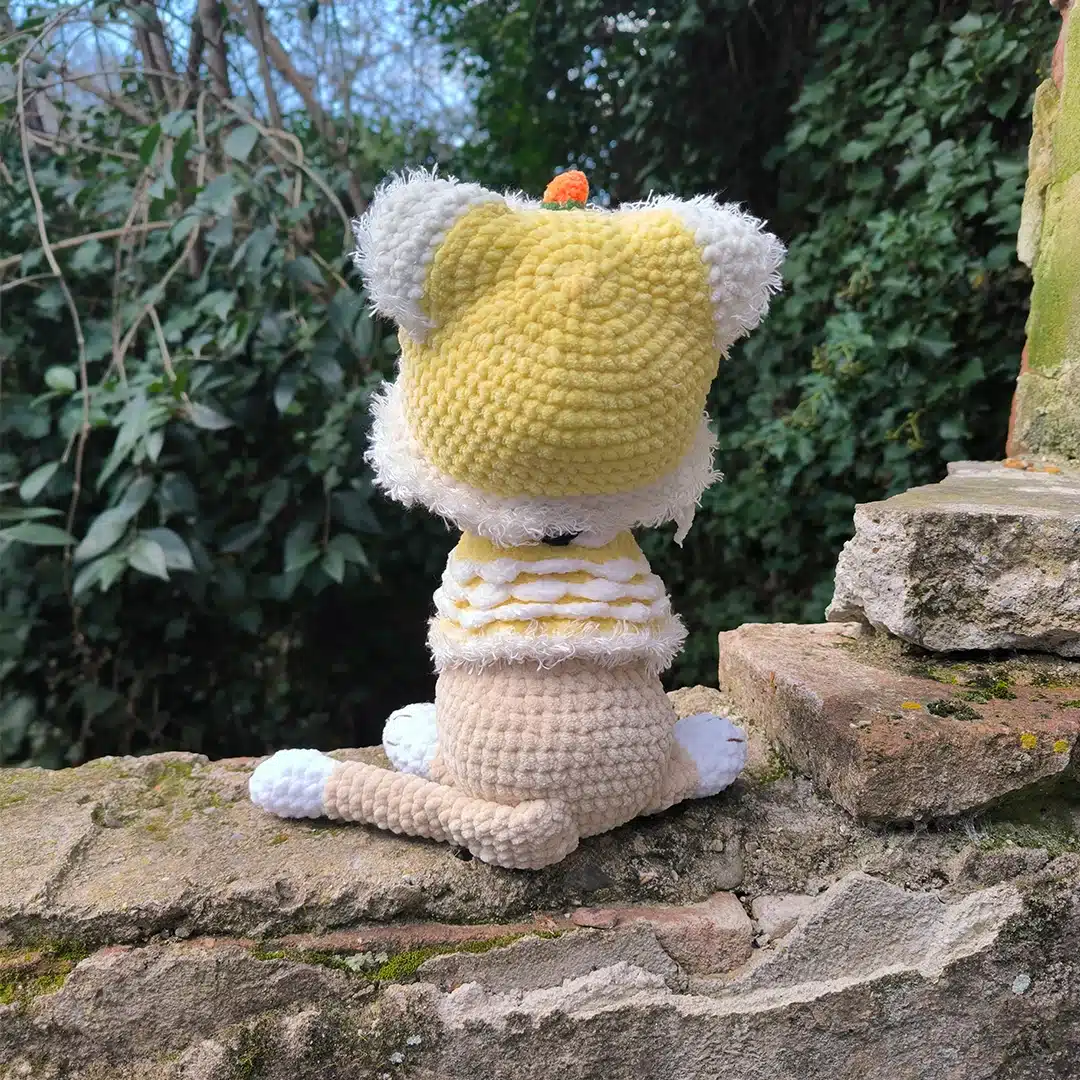 Chat au crochet et son habit jaune de dragon vu de dos
