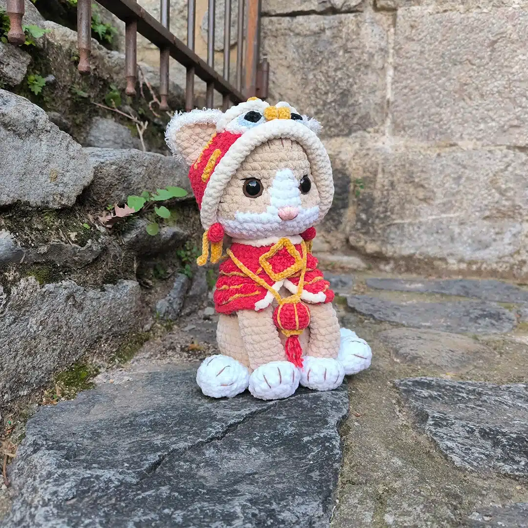 Amigurumi chat Shishimao au crochet avec son habit de dragon rouge