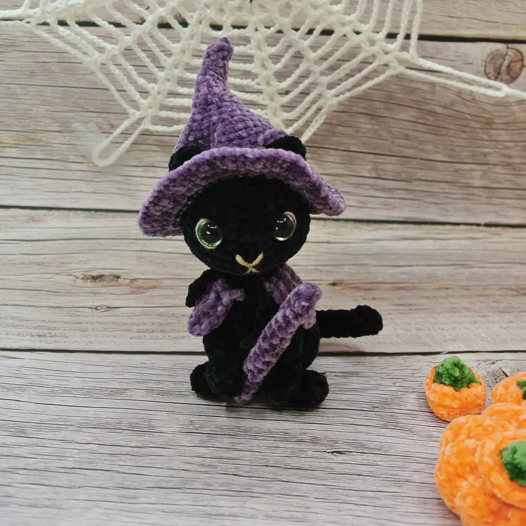 Amigurumi chat noir d'Halloween avec son déguisement violet de sorcier