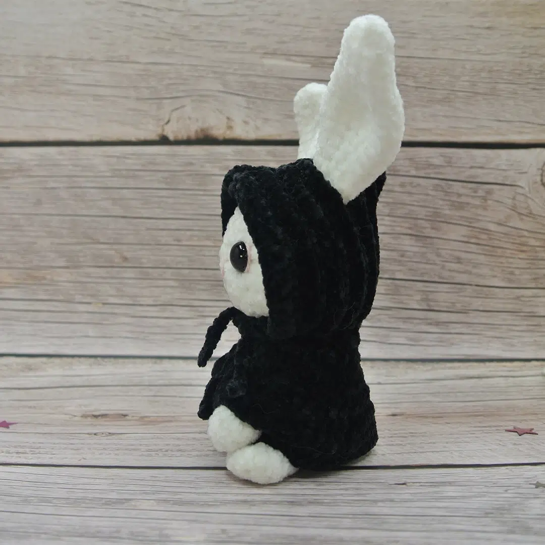 Amigurumi lapin blanc d'Halloween vu de profil et son déguisement noir