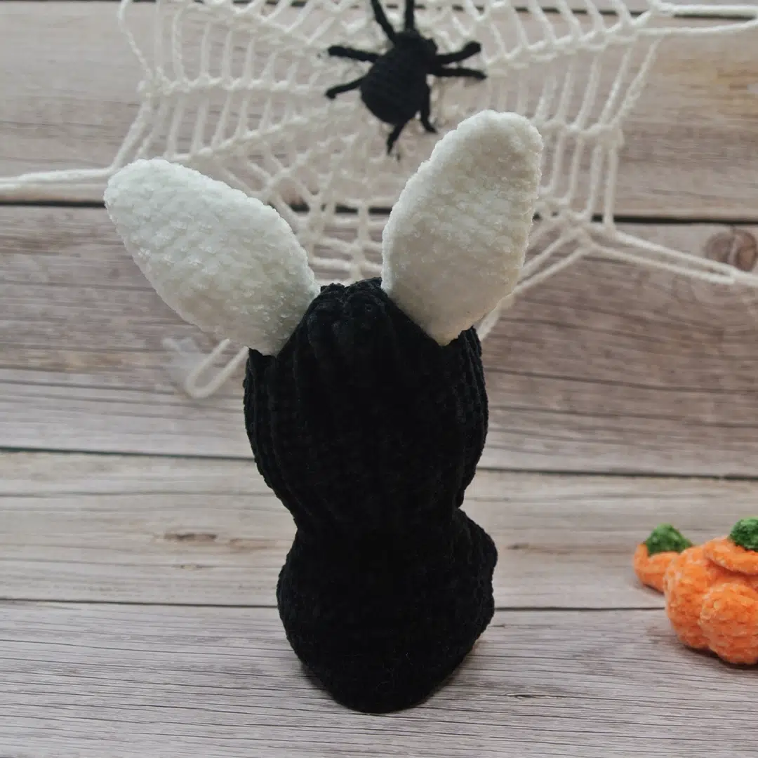 Amigurumi lapin blanc d'Halloween vu de dos avec son déguisement noir