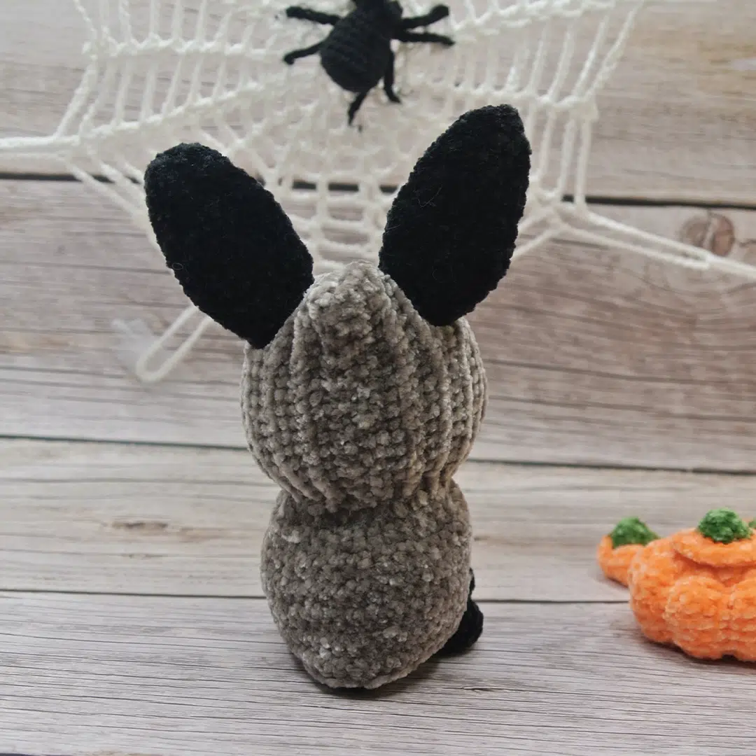Amigurumi lapin noir d'Halloween vu de dos avec son déguisement gris