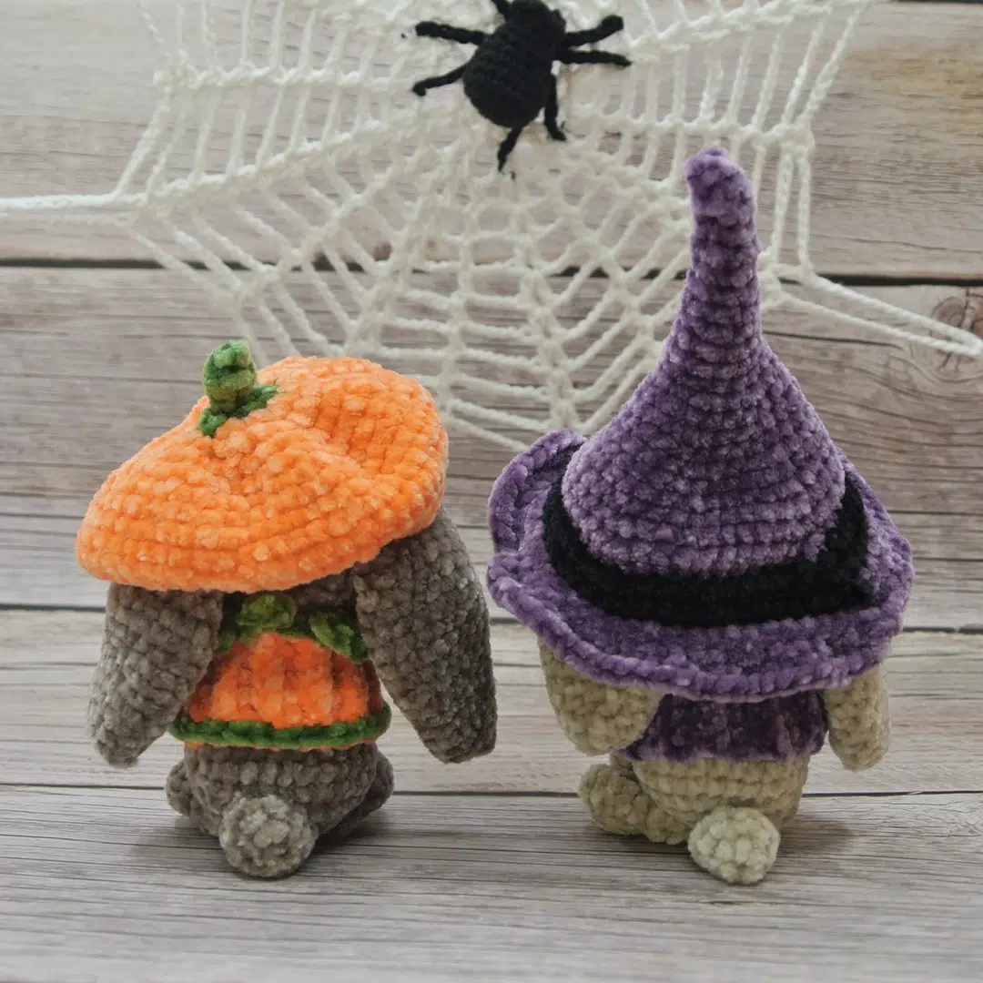 Deux amigurumis lapins d'Halloween et leurs déguisements citrouille et sorcière avec une vue de dos
