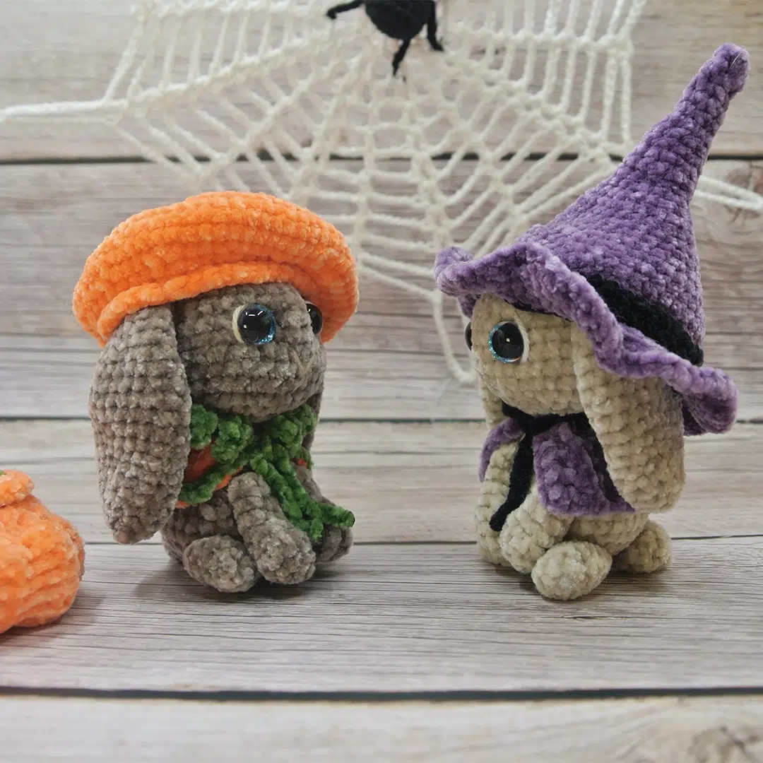 Deux amigurumis lapins d'Halloween avec leurs déguisements citrouille et sorcière qui se regardent